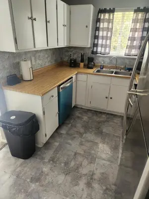 a kitchen with white cabinets and a blue dishwasher at FC Suites in Cincinnati
