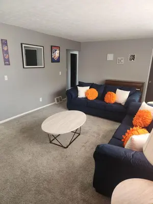 a living room with a blue couch and a table at FC Suites in Cincinnati