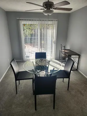 a dining room with a glass table and chairs at FC Suites in Cincinnati