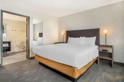 a hotel room with a large bed and a bathroom at Home2 Suites By Hilton Reynoldsburg Columbus East in Columbus