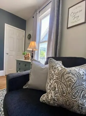 a living room with a blue couch and a window at Cozy Main Street Flat in Adrian