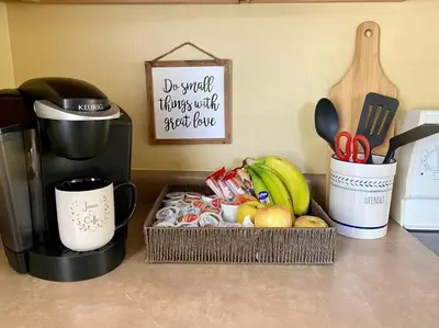 a basket of fruit on a counter next to a coffee maker at Cozy Main Street Flat in Adrian
