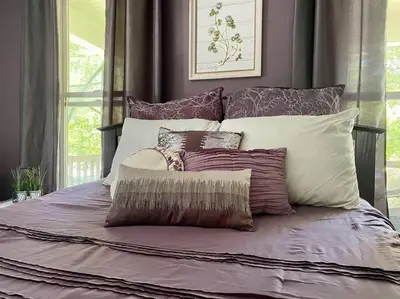 a bed with a bunch of pillows on it at Cozy Main Street Flat in Adrian