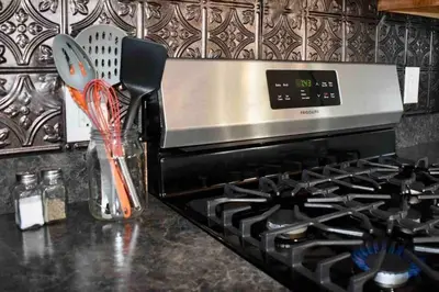 a kitchen counter with a stove and a vase with utensils at Cozy Garden House in Adrian