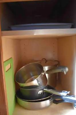 a shelf with two pots and pans in a drawer at Cozy Garden House in Adrian