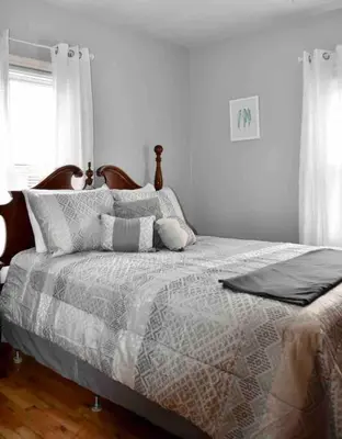 a bedroom with a bed with a comforter and pillows at Cozy Garden House in Adrian