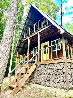 a small house with a stone wall at HOT TUB -Secluded Cabin Cave Run Lake and near Red River Gorge in Wellington