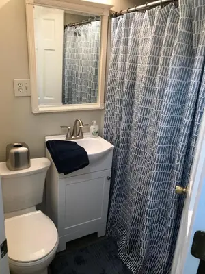 a bathroom with a sink and a shower curtain at Take me to the River! in Zanesville