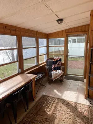 a room with a table and a chair and windows at Take me to the River! in Zanesville