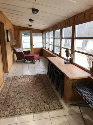 a room with a table and chairs and windows at Take me to the River! in Zanesville