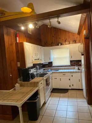 a kitchen with white appliances and wooden cabinets at Take me to the River! in Zanesville