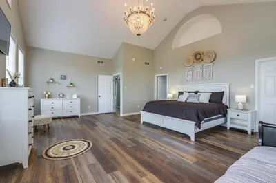 a bedroom with a bed and a chandelier at Sprawling Kentucky Getaway with Pool and Hot Tub! in Berry