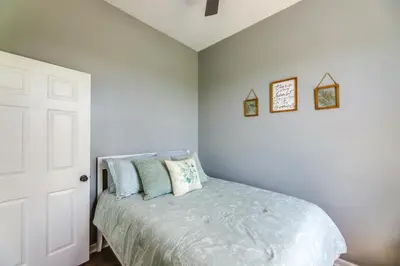 a bedroom with a bed with blue pillows on it at Sprawling Kentucky Getaway with Pool and Hot Tub! in Berry
