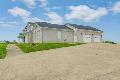 a large house with a driveway in front of it at Sprawling Kentucky Getaway with Pool and Hot Tub! in Berry