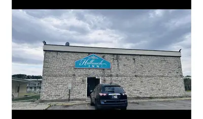 a car parked in front of a brick building at Hallmark Inn By OYO Fort Wayne in Fort Wayne