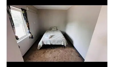 a bedroom with a bed in a room with a window at Hallmark Inn By OYO Fort Wayne in Fort Wayne