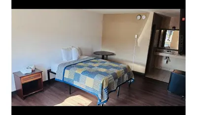 a hotel room with a bed and a table at Hallmark Inn By OYO Fort Wayne in Fort Wayne
