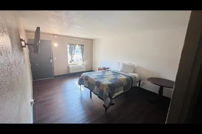 a small bedroom with a bed and a window at Hallmark Inn By OYO Fort Wayne in Fort Wayne