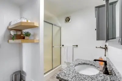 a bathroom with a sink and a glass shower at Ohio Farmhouse Retreat with Fire Pit and Patio in Monroeville