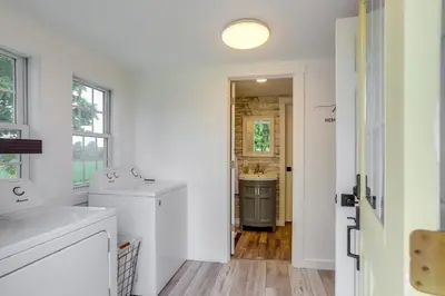 a white bathroom with a sink and a mirror at Ohio Farmhouse Retreat with Fire Pit and Patio in Monroeville
