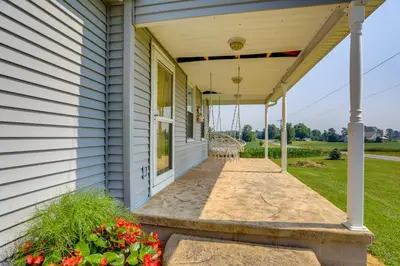 a porch with awning on a house at Ohio Farmhouse Retreat with Fire Pit and Patio in Monroeville