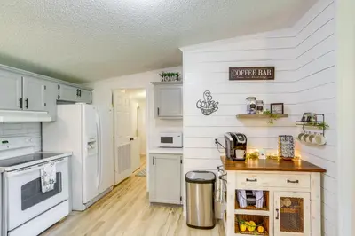 a kitchen with white appliances and a wooden floor at North Fairfield Family Home with Hot Tub and Porch! in Willard