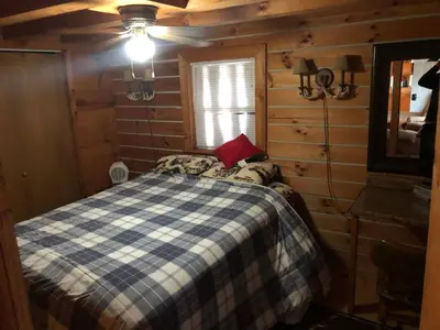 a bedroom with a bed in a log cabin at Lodge 65AC Zanesville Muskingum AEP WIFI CELL SVC in Blue Rock