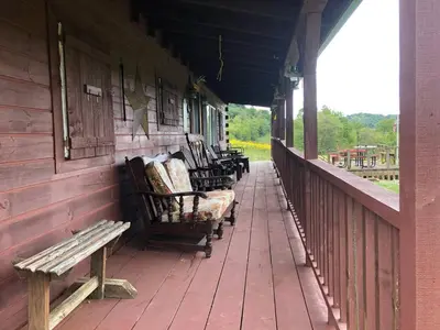 a row of benches sitting on the porch of a building at Lodge 65AC Zanesville Muskingum AEP WIFI CELL SVC in Blue Rock