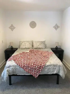 a bed with a red and white comforter in a bedroom at 3BR 1BA North End Walk to the Hospital in Zanesville