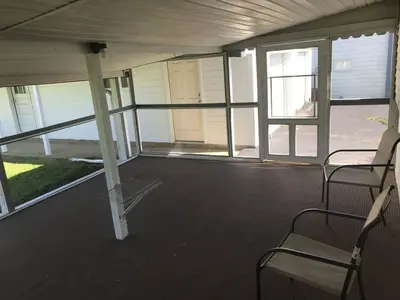an empty room with two chairs and windows at 3BR 1BA North End Walk to the Hospital in Zanesville