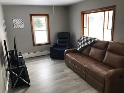 a living room with a brown couch and a chair at 3BR 1BA North End Walk to the Hospital in Zanesville