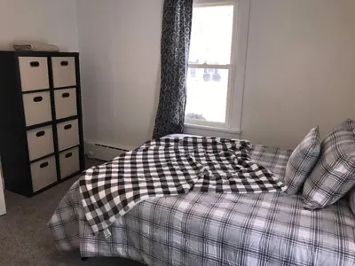 a bedroom with a plaid couch and a window at 3BR 1BA North End Walk to the Hospital in Zanesville