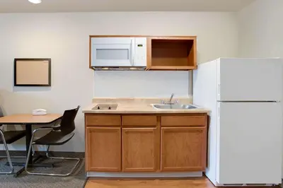 a kitchen with a sink and a white refrigerator at WoodSpring Suites Columbus North I-270 in Columbus