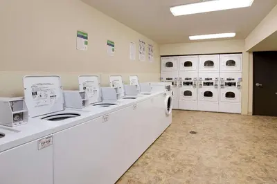 a laundry room with white washers and dryers at WoodSpring Suites Columbus North I-270 in Columbus