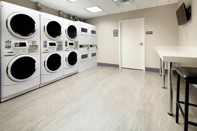 a laundry room with four washing machines and a table at Residence Inn by Marriott Columbus Dublin in Dublin
