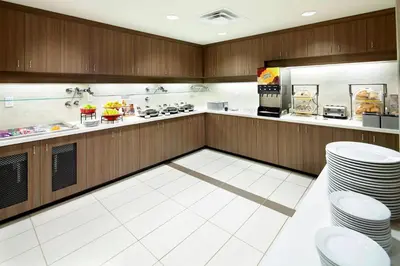 a large kitchen with white floors and wooden cabinets at Residence Inn by Marriott Columbus Dublin in Dublin