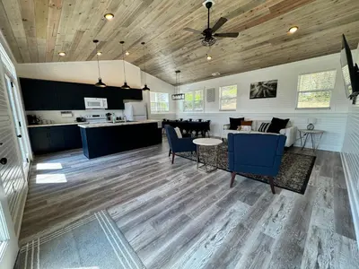 a living room with blue chairs and a kitchen at 100 Acre Relaxing Retreat Near ARK- The Cabin in Williamstown