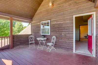 a wooden deck with chairs and a table on it at Quiet Family Cabin in Hamden Hot Tub and Game Room! in Hamden