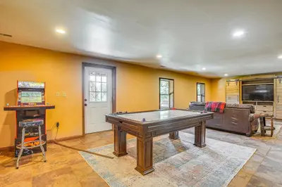 a living room with a pool table and a couch at Quiet Family Cabin in Hamden Hot Tub and Game Room! in Hamden