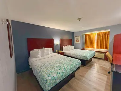 a hotel room with two beds and a window at BlissPoint Inn & Suites, Northwood in Northwood
