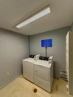 a room with a washing machine and a blue wall at BlissPoint Inn & Suites, Northwood in Northwood