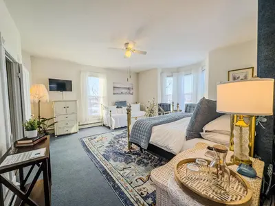 a bedroom with a bed and a living room at Victorian Inn Bed And Breakfast in Marblehead