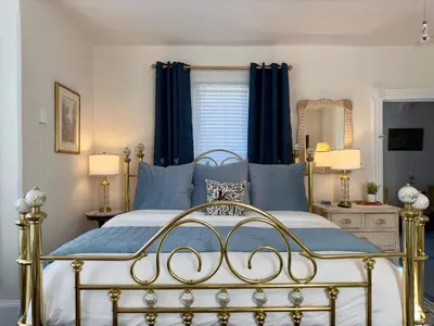 a bedroom with a bed with blue pillows at Victorian Inn Bed And Breakfast in Marblehead