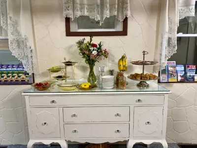 a white dresser with food on top of it at Victorian Inn Bed And Breakfast in Marblehead