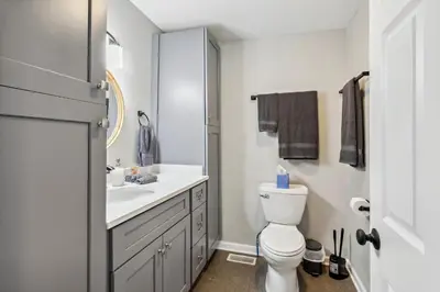 a white bathroom with a sink and a toilet at Spacious Home with Game Room - 9 mins from Cedar Point in Sandusky