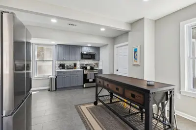 a kitchen with gray cabinets and a wooden table at Spacious Home with Game Room - 9 mins from Cedar Point in Sandusky