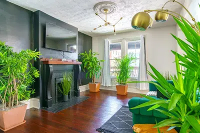 a living room with plants and a fireplace at Jungle House Columbus Short North Downtown Free Parking - Steps to Convention Center & Nationwide Arena - 2BR Luxury Home - Sleeps 8 - Over 5,800 Five Star Stays in Columbus