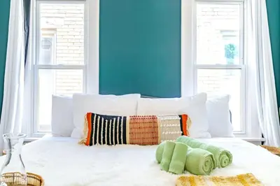 a bedroom with a white bed with a blue wall at Jungle House Columbus Short North Downtown Free Parking - Steps to Convention Center & Nationwide Arena - 2BR Luxury Home - Sleeps 8 - Over 5,800 Five Star Stays in Columbus