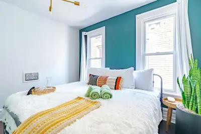 a bedroom with blue walls and a bed with two towels at Jungle House Columbus Short North Downtown Free Parking - Steps to Convention Center & Nationwide Arena - 2BR Luxury Home - Sleeps 8 - Over 5,800 Five Star Stays in Columbus