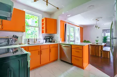 a kitchen with orange cabinets and a sink at Jungle House Columbus Short North Downtown Free Parking - Steps to Convention Center & Nationwide Arena - 2BR Luxury Home - Sleeps 8 - Over 5,800 Five Star Stays in Columbus